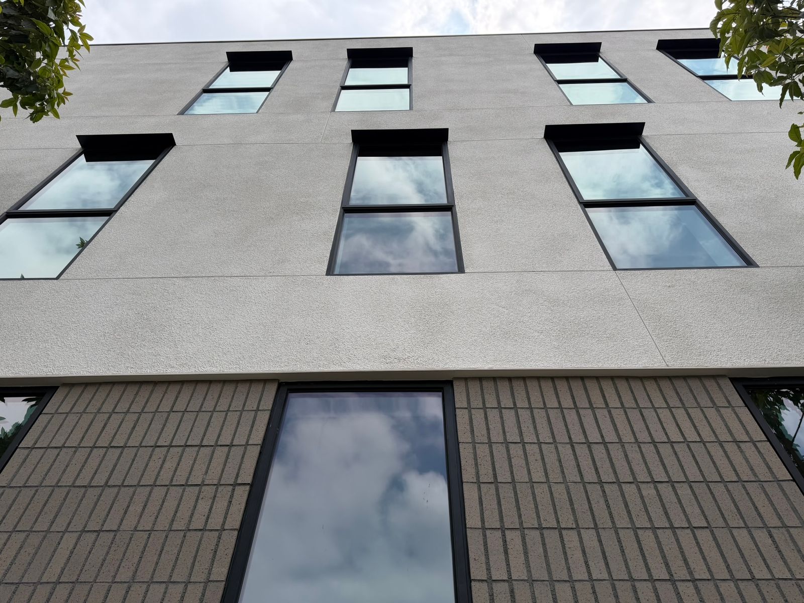 Facade detail: deep-set windows over a textured masonry base